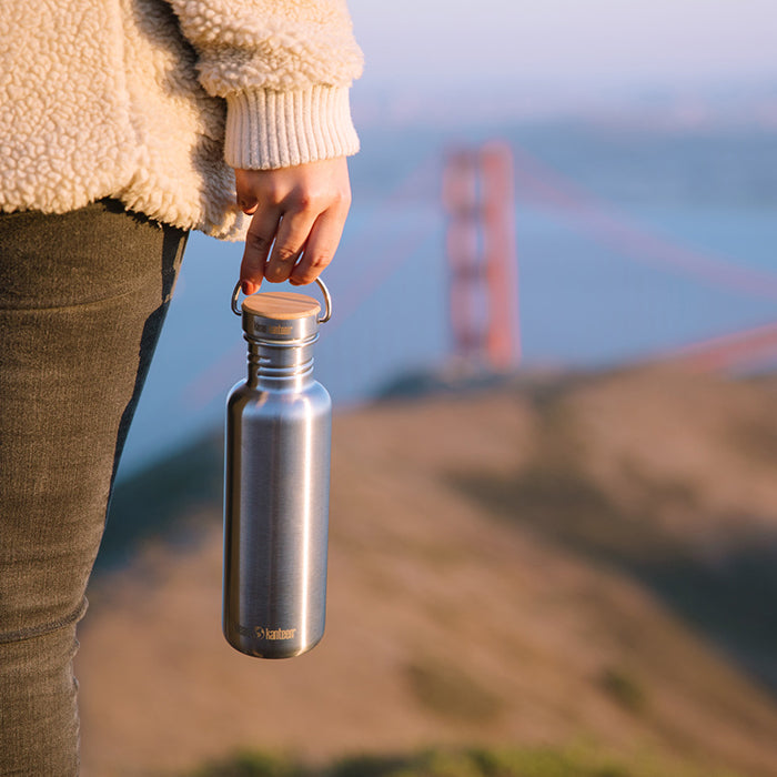 27oz-reflect-with-bamboo-cap-r5 K27SSLRF-BS-BAMBOO_reflect_bottle_bridge_lifestyle.jpg